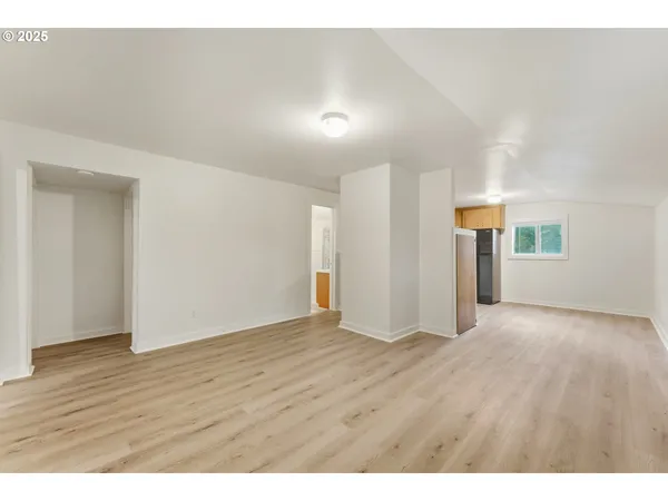 a view of an empty room with wooden floor