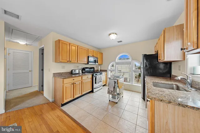 a kitchen with granite countertop a stove sink and cabinets