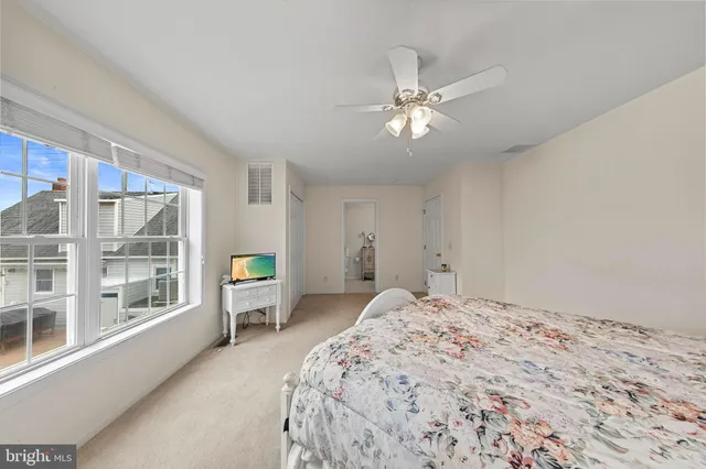 a spacious bedroom with a large bed and a chandelier