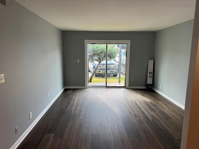 an empty room with wooden floor and a window