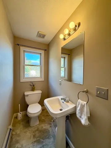 a bathroom with a toilet sink and mirror