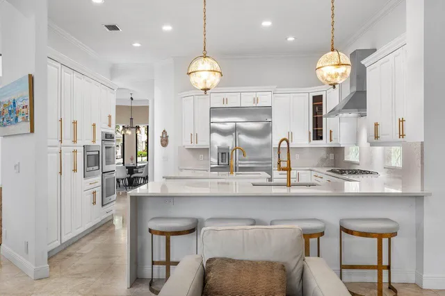 a kitchen that has a lot of cabinets and stainless steel appliances