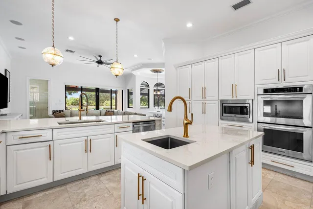 a kitchen with stainless steel appliances granite countertop a sink a stove and a window