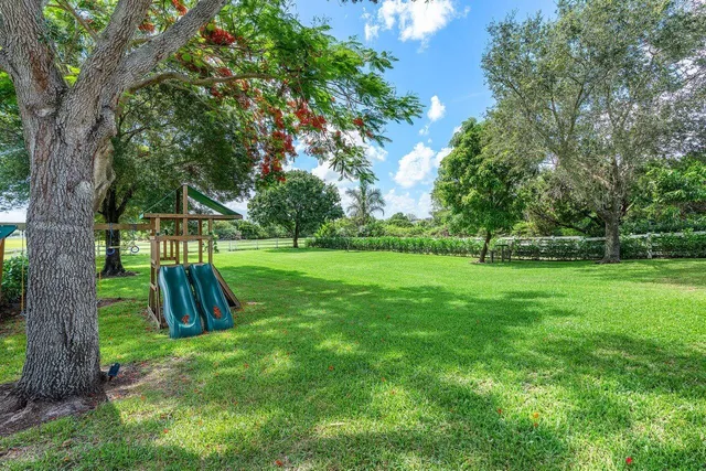 a view of grassy field with benches and trees all around