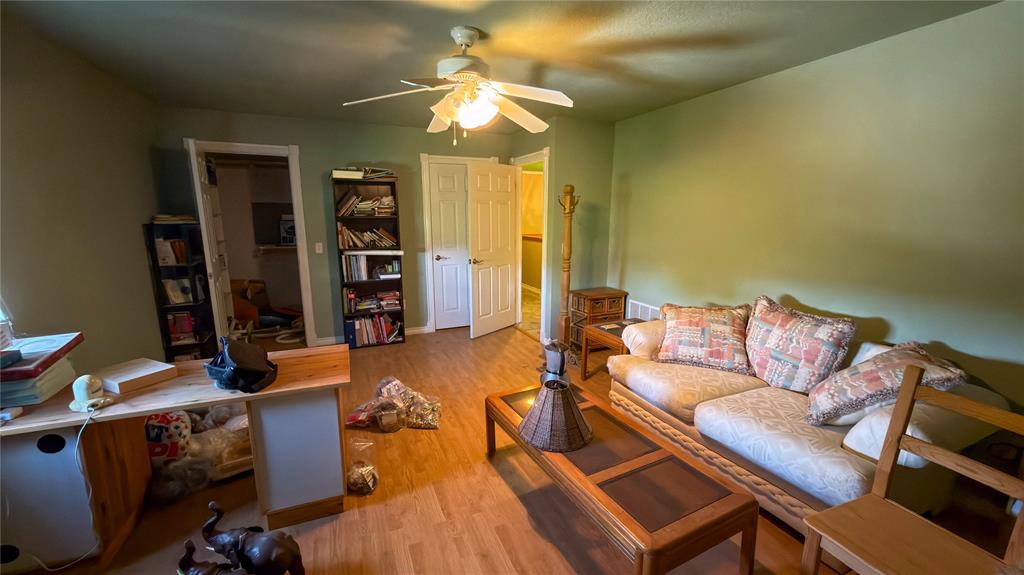 2900 Robinson Road Denton, TX 76210 - Photo 17 of 33 Interior room featuring wood-finish flooring, a ceiling fan with integrated lighting, and white trim around doorways