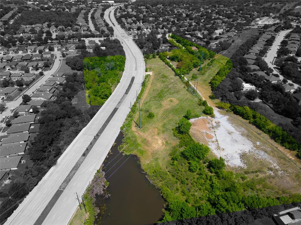 2900 Robinson Road Denton, TX 76210 - Photo 2 of 33 Expansive vacant land parcel featuring a water body, mature trees, and a concrete road border