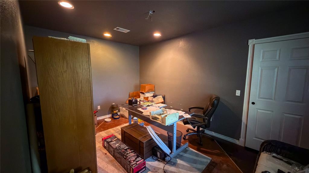 2900 Robinson Road Denton, TX 76210 - Photo 22 of 33 Recessed lighting illuminates a room featuring dark walls, a white paneled door, and dark baseboards