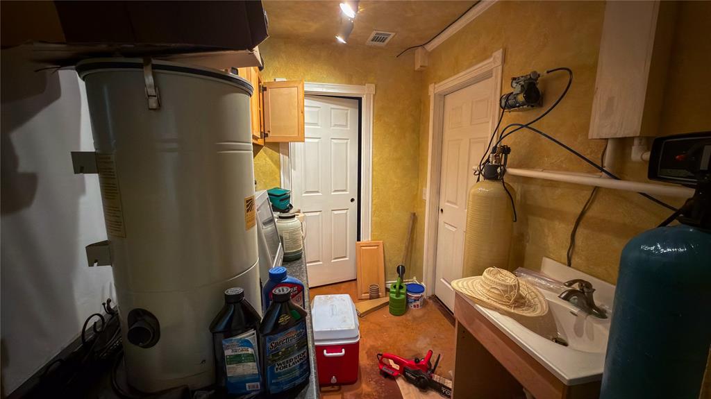2900 Robinson Road Denton, TX 76210 - Photo 23 of 33 Utility room with integrated water filtration system, cabinetry, and a work sink