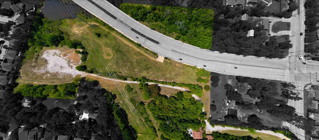 2900 Robinson Road Denton, TX 76210 - Photo 31 of 33 Expansive land parcel featuring a mix of cleared and treed areas, bordered by a multi-lane roadway and a body of water