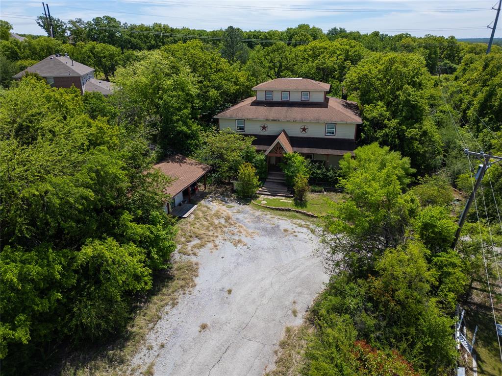 2900 Robinson Road Denton, TX 76210 - Photo 32 of 33 Multi-level property surrounded by mature trees, featuring a prominent central structure with a gabled roof and multiple windows