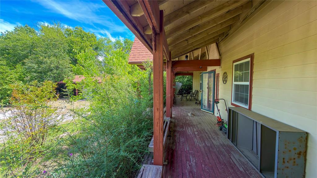 2900 Robinson Road Denton, TX 76210 - Photo 6 of 33 Expansive covered porch featuring a painted wood floor, exposed ceiling beams, and a wood-framed window