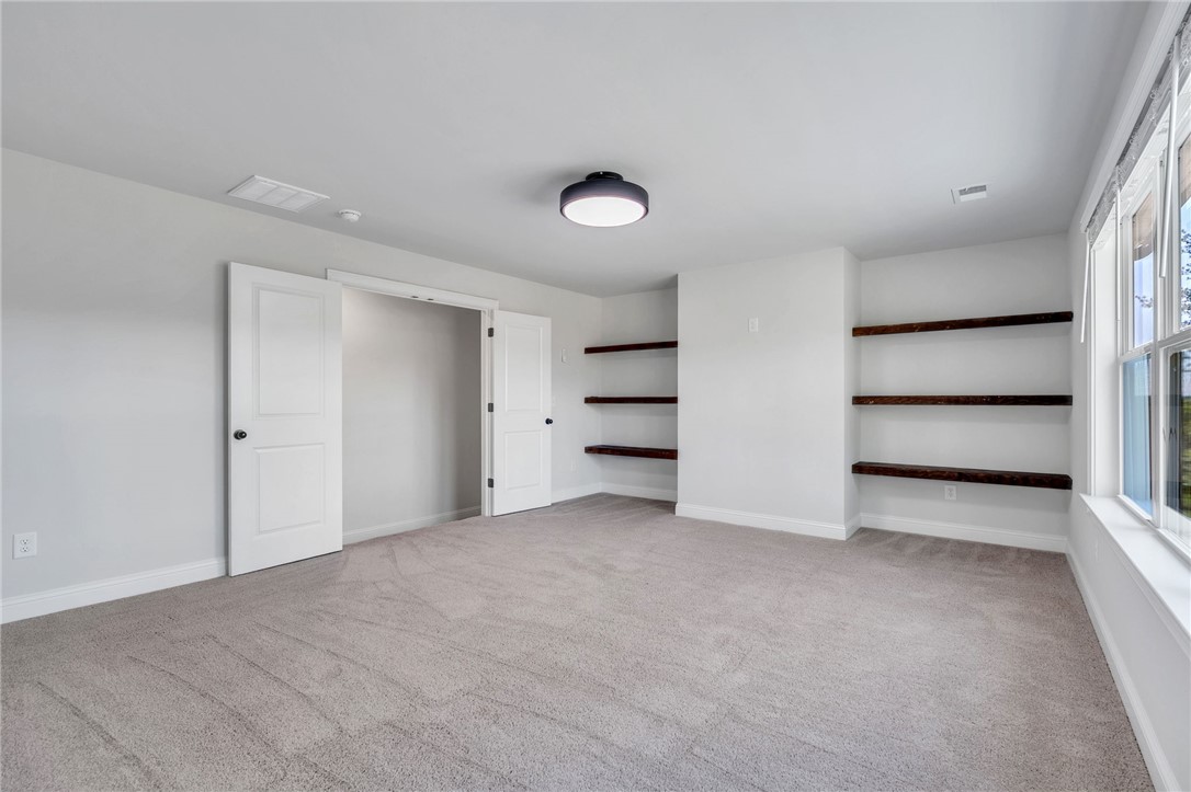 226 Holly Br Road Piedmont, SC 29673 - Photo 26 of 44 A well-lit room featuring built-in shelving, soft carpeting, and abundant natural light from wide windows.
