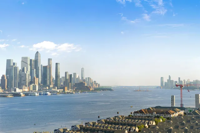 a view of an empty room with wooden floor and a bathroom