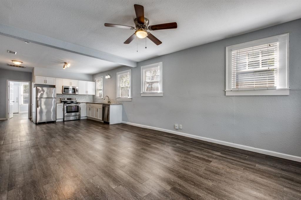 a view of empty room with wooden floor and ceiling fan