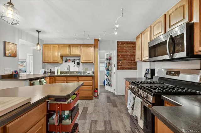 a kitchen with stainless steel appliances a stove sink microwave and cabinets