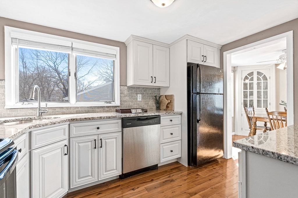 80 Neal Street Malden, MA 02148 - Photo 12 of 39 a kitchen with granite countertop a refrigerator a sink and white cabinets with wooden floor