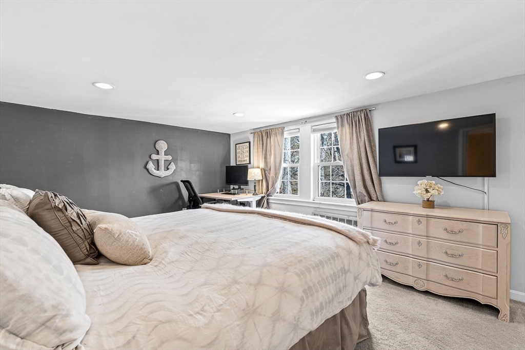 80 Neal Street Malden, MA 02148 - Photo 24 of 39 a bedroom with a large bed and a flat tv screen on dresser
