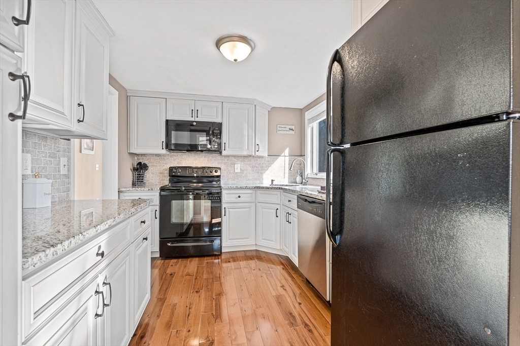 80 Neal Street Malden, MA 02148 - Photo 10 of 39 a kitchen with granite countertop a refrigerator and a stove top oven