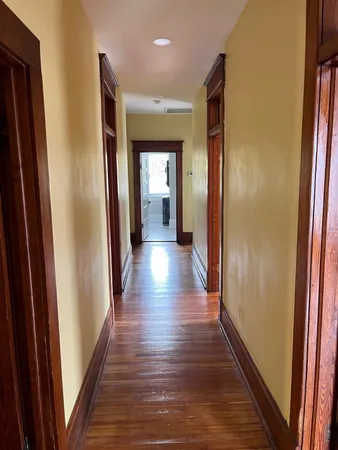a view of a hallway with wooden floor