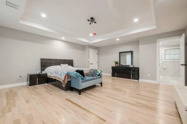a bedroom with a large bed and a flat tv screen