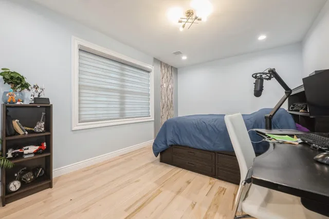 a large bed sitting in a bedroom next to a window