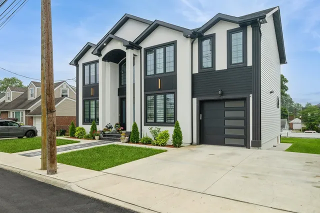 a front view of a house with a yard and garage