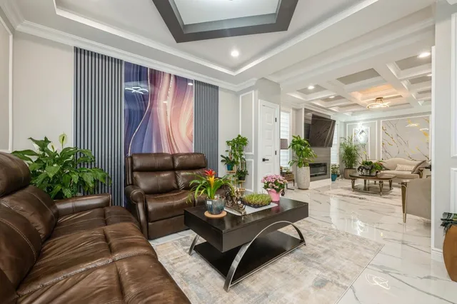 a living room with furniture potted plant and a large window