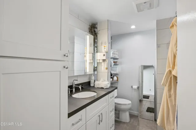 a bathroom with a granite countertop sink toilet and shower