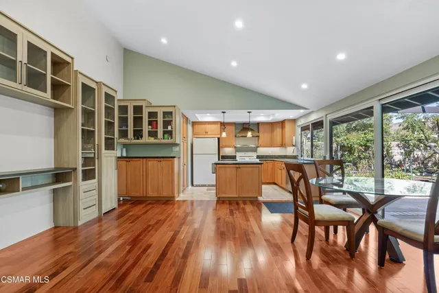 a living room with stainless steel appliances kitchen island granite countertop furniture a large window and wooden floor