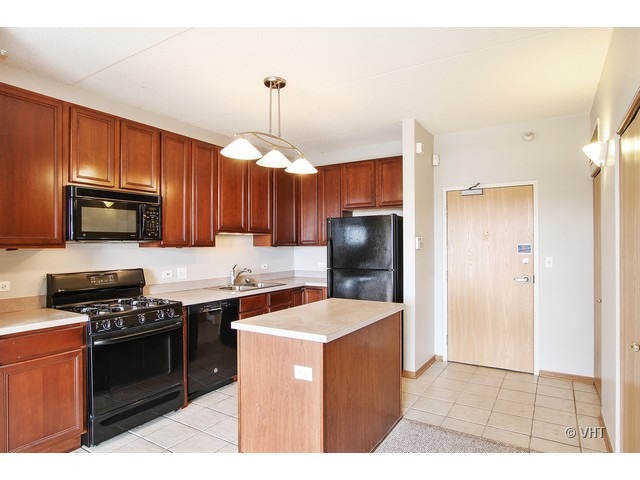 515 Main Street, Unit 507 Evanston, IL 60202 - Photo 4 of 10 a kitchen with stainless steel appliances a sink a stove a refrigerator cabinets and a dining table