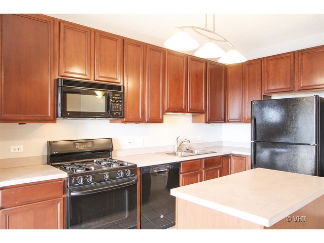 515 Main Street, Unit 507 Evanston, IL 60202 - Photo 5 of 10 a kitchen with stainless steel appliances granite countertop a refrigerator stove top oven with a sink and dishwasher