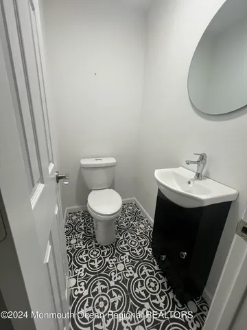 a bathroom with a sink toilet and a mirror
