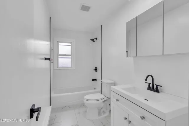 a bathroom with a toilet sink a mirror and shower