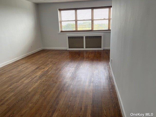 88-29 155th Avenue, Unit 6D Queens, NY 11414 - Photo 11 of 16 an empty room with wooden floor and windows