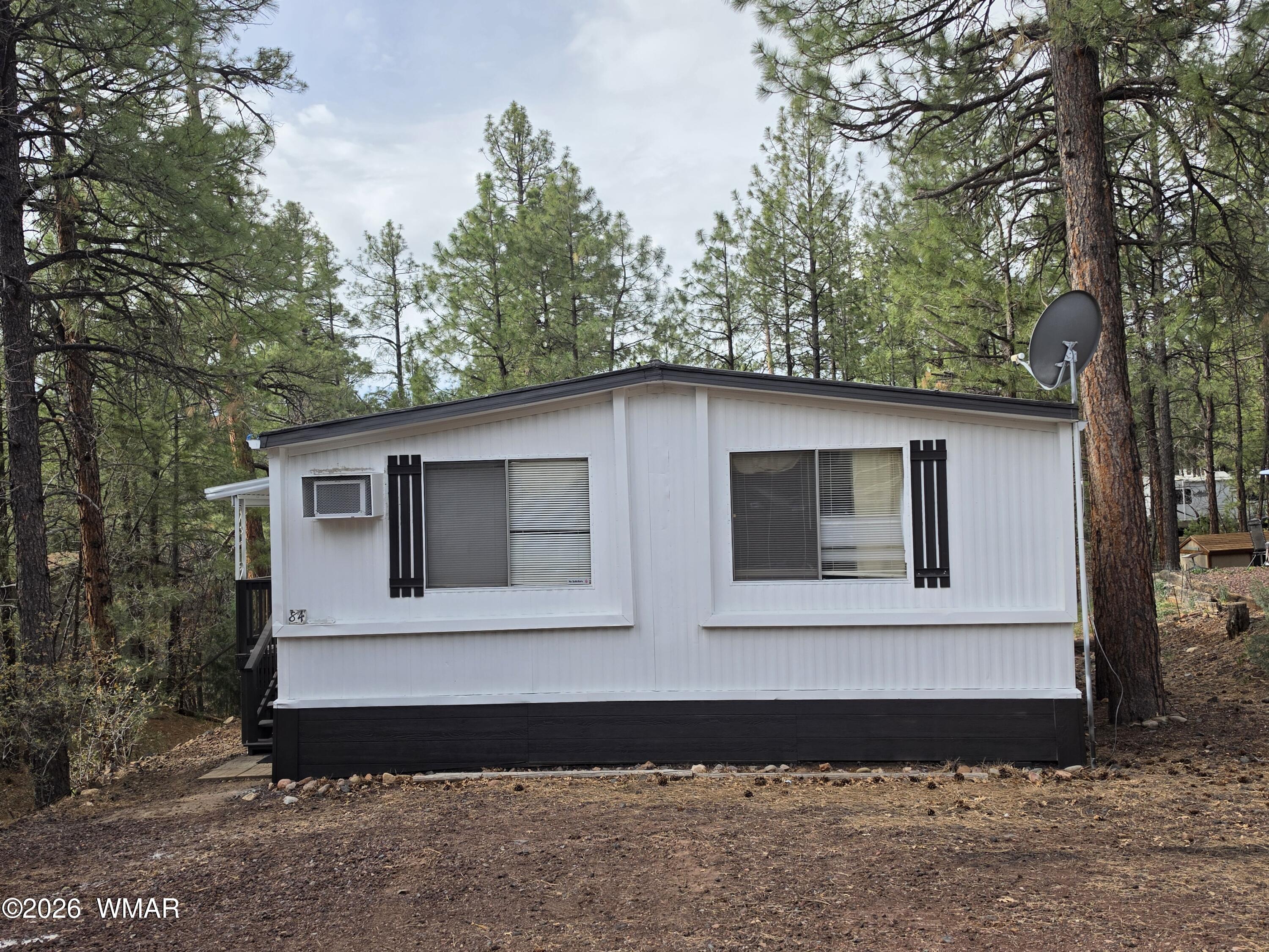 2800 South White Mountain Road, Unit 84 Show Low, AZ 85901 - Photo 1 of 13 a front view of a house with a garden