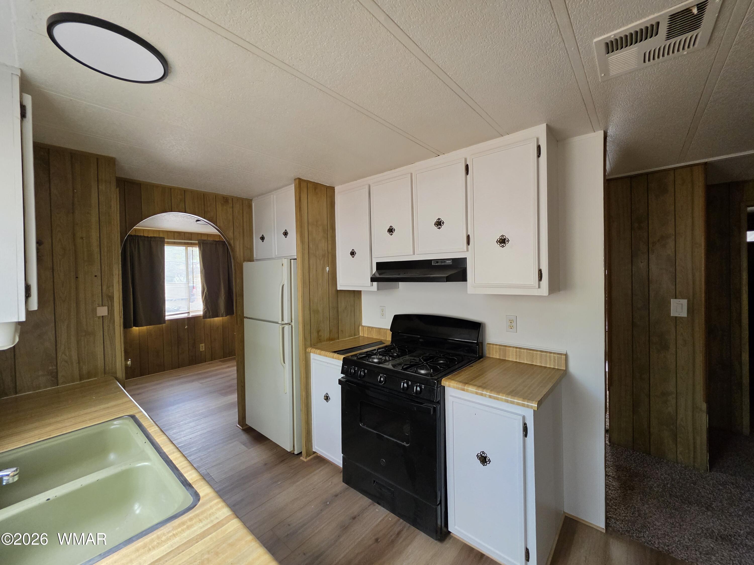 2800 South White Mountain Road, Unit 84 Show Low, AZ 85901 - Photo 7 of 13 a kitchen with a refrigerator and a stove top oven