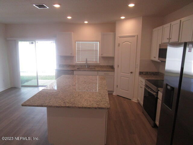 4165 Deer Trce Lane Jacksonville, FL 32257 - Photo 4 of 13 a kitchen with stainless steel appliances granite countertop a refrigerator a sink a stove a microwave and island