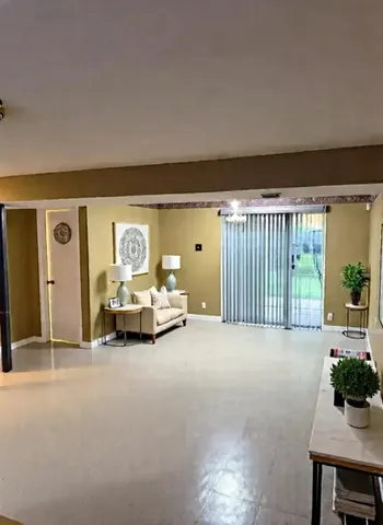 a view of a livingroom with furniture and floor to ceiling window