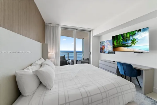 a bedroom with a large bed and a flat screen tv