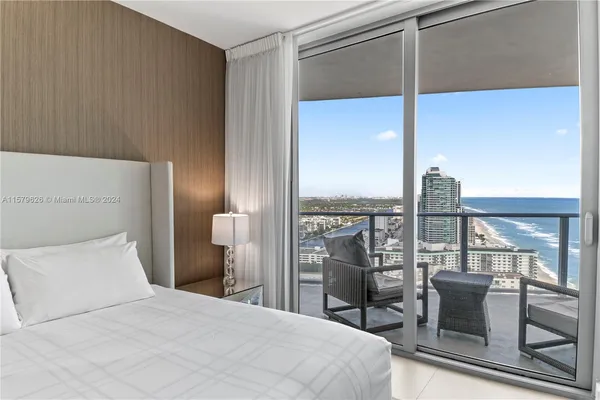 a bedroom with a large bed and a chandelier