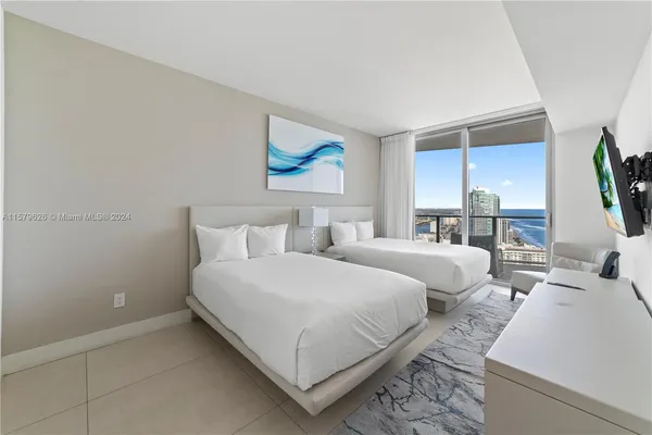 a bedroom with bed and a flat screen tv