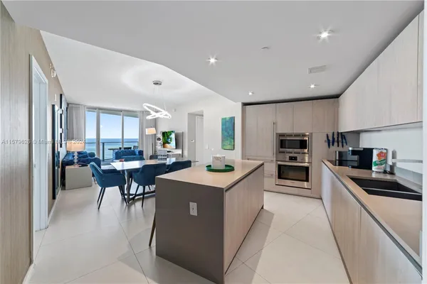 a kitchen with stainless steel appliances kitchen island granite countertop a sink a stove and a refrigerator