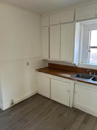 a kitchen with granite countertop white cabinets and sink
