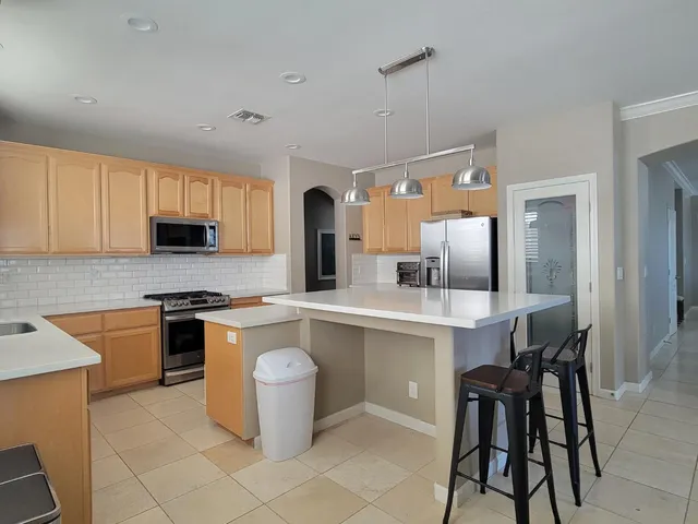 a kitchen with a sink a stove cabinets and a window