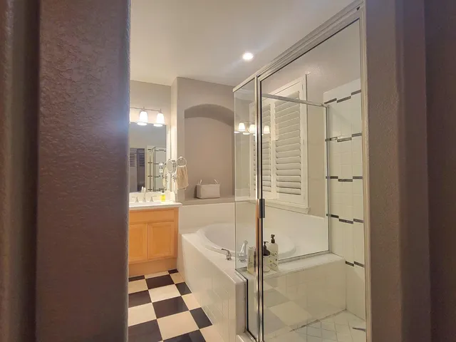 a bathroom with a bathtub a sink and a large mirror