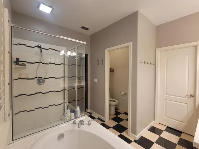 a backyard of a house with barbeque oven and a tree