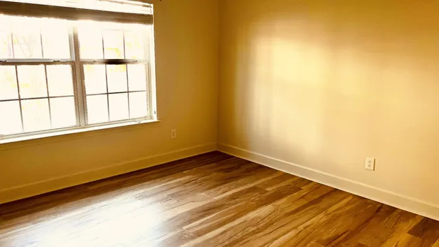 a view of a room with wooden floor and small window