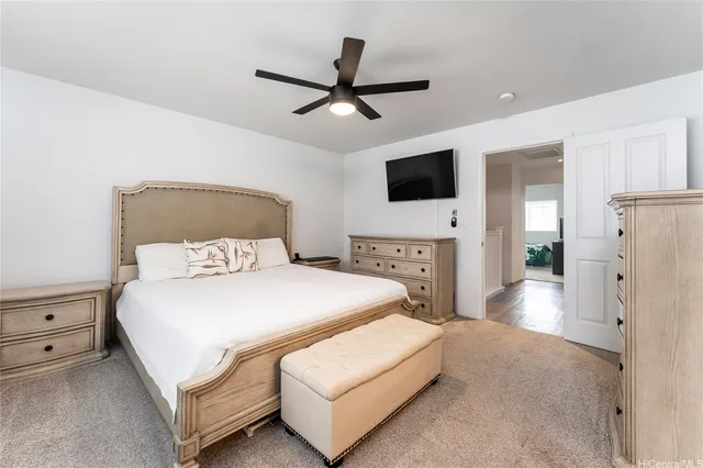 a spacious bedroom with a bed and a flat screen tv