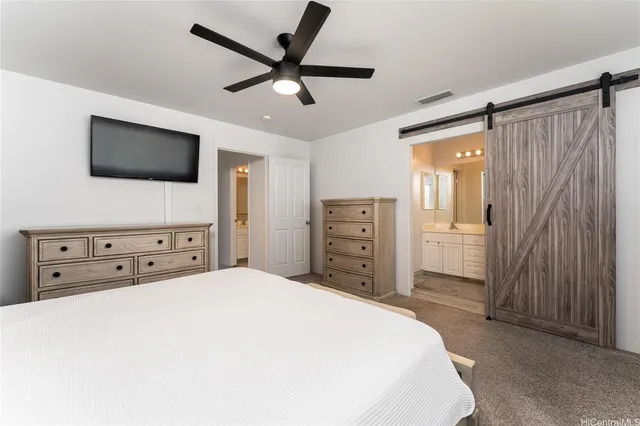 a spacious bedroom with a bed and a television