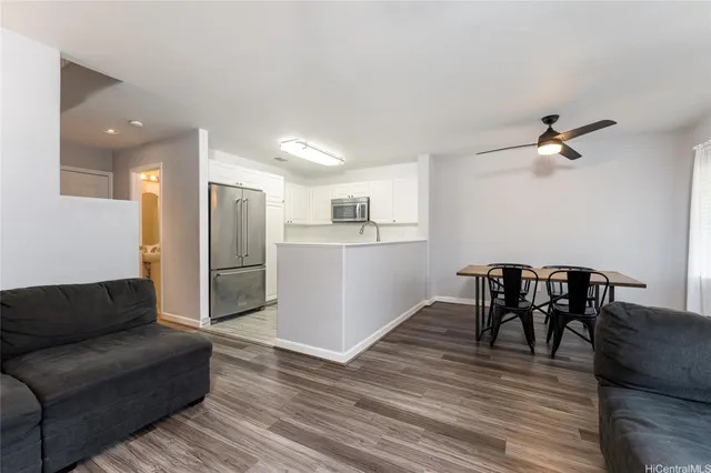 a living room with furniture and a dining table with kitchen view